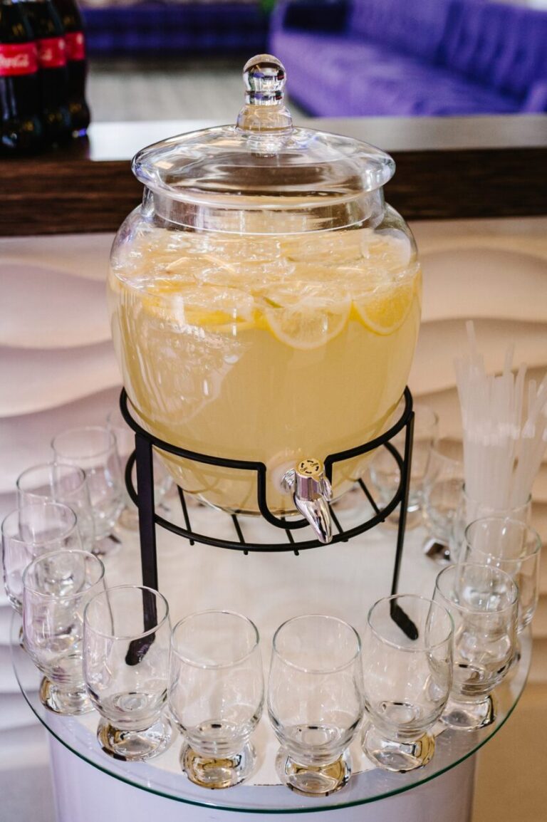 Fontaine à cocktail installée sur un bar en libre-service avec verres et garnitures fraîches.