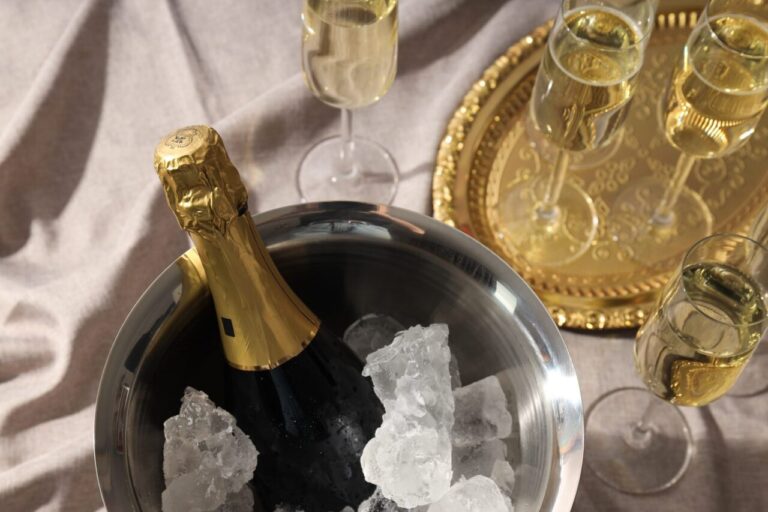Bouteille de champagne rafraîchie dans un seau à glace posé sur un plateau avec une serviette pour protéger la nappe.